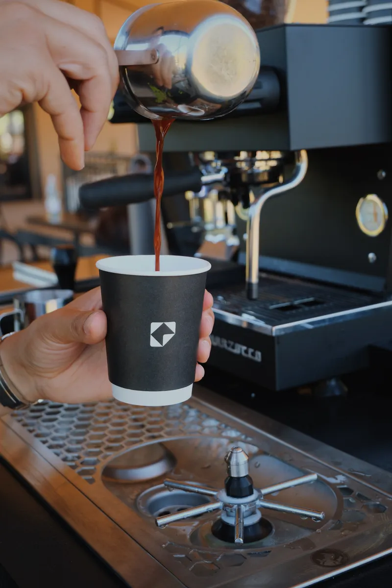 Espresso being poured into a branded cup