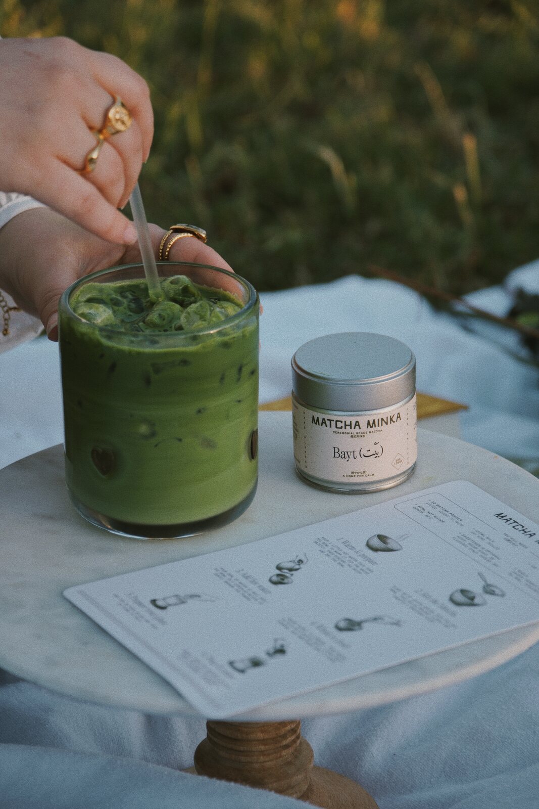 Iced matcha latte with Matcha Minka tin and menu card