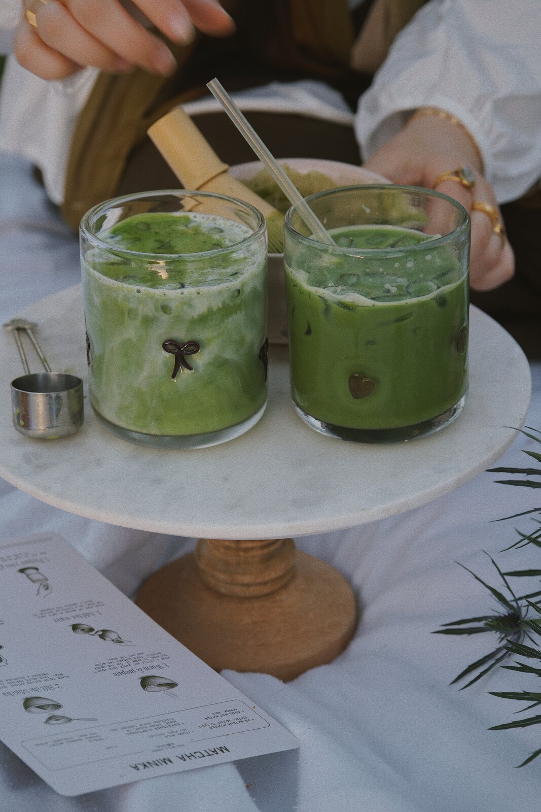 Two ceremonial matcha lattes on a marble stand
