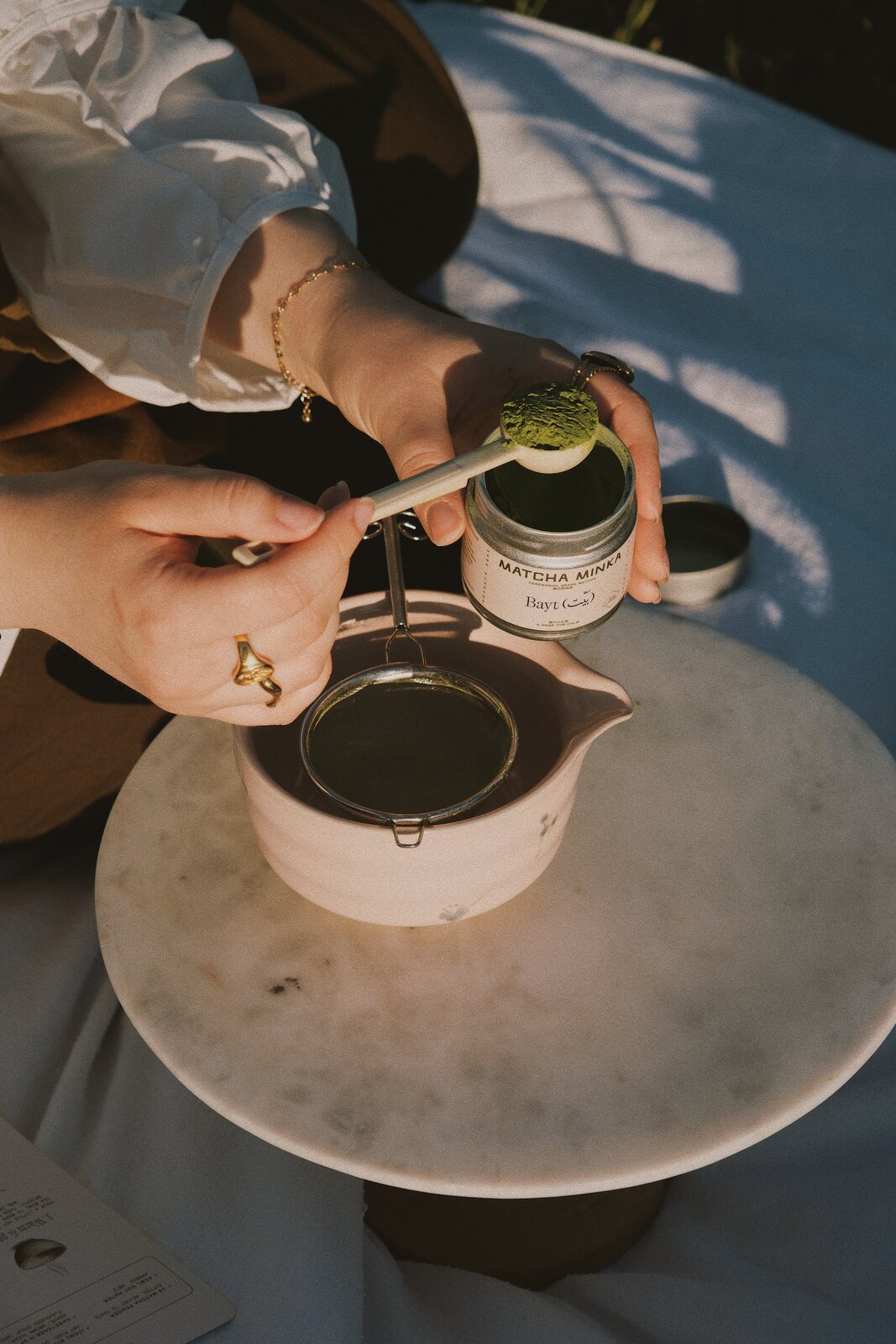 Scooping ceremonial matcha into a sieve