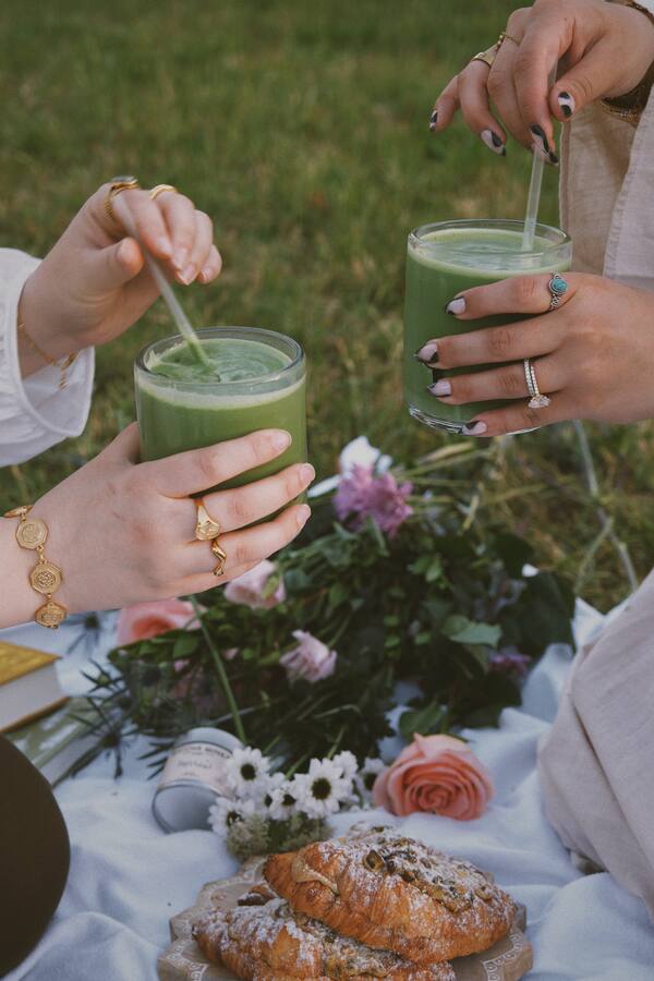 Two matcha lattes raised in a toast
