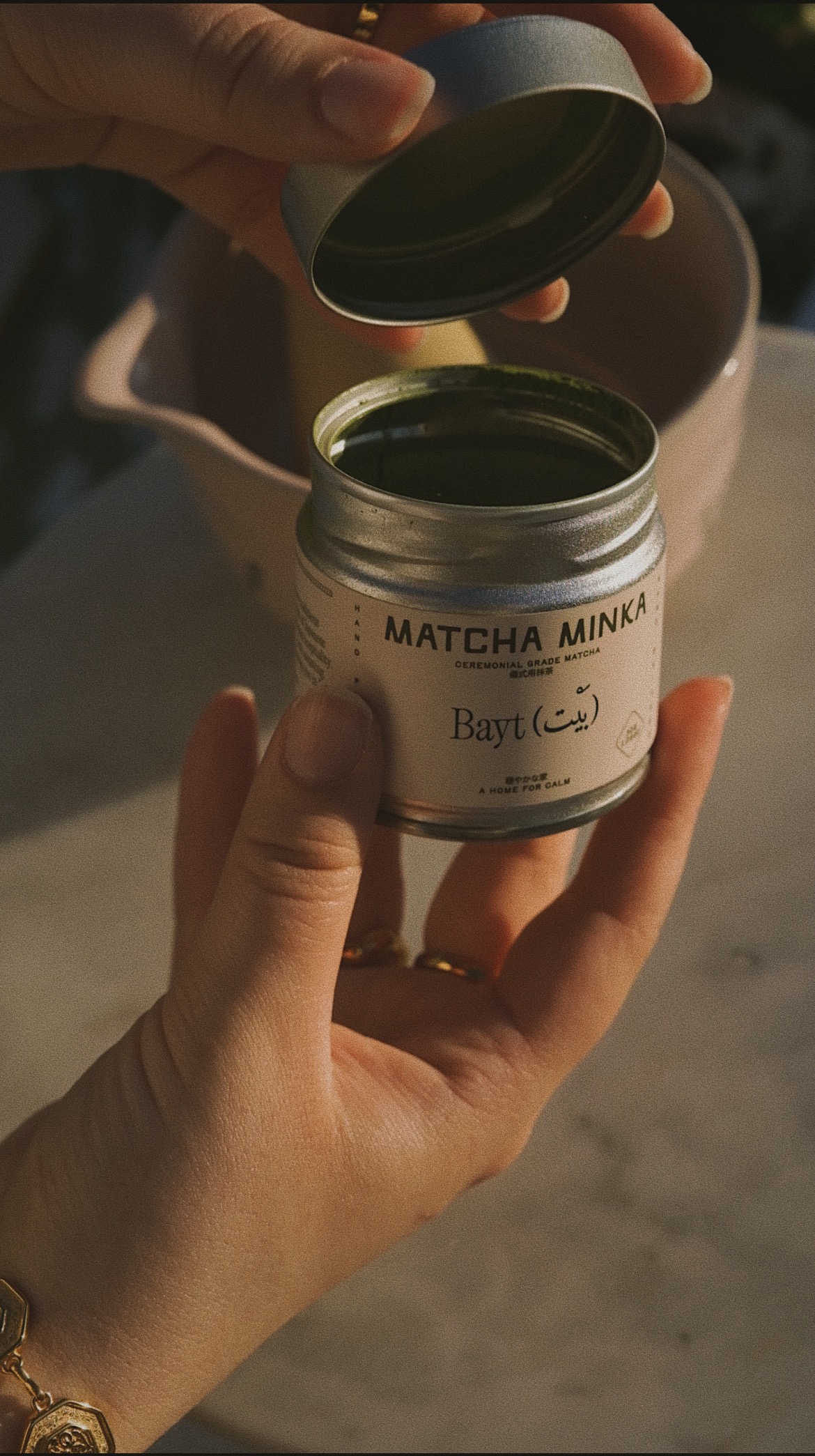 Hand opening the Matcha Minka tin